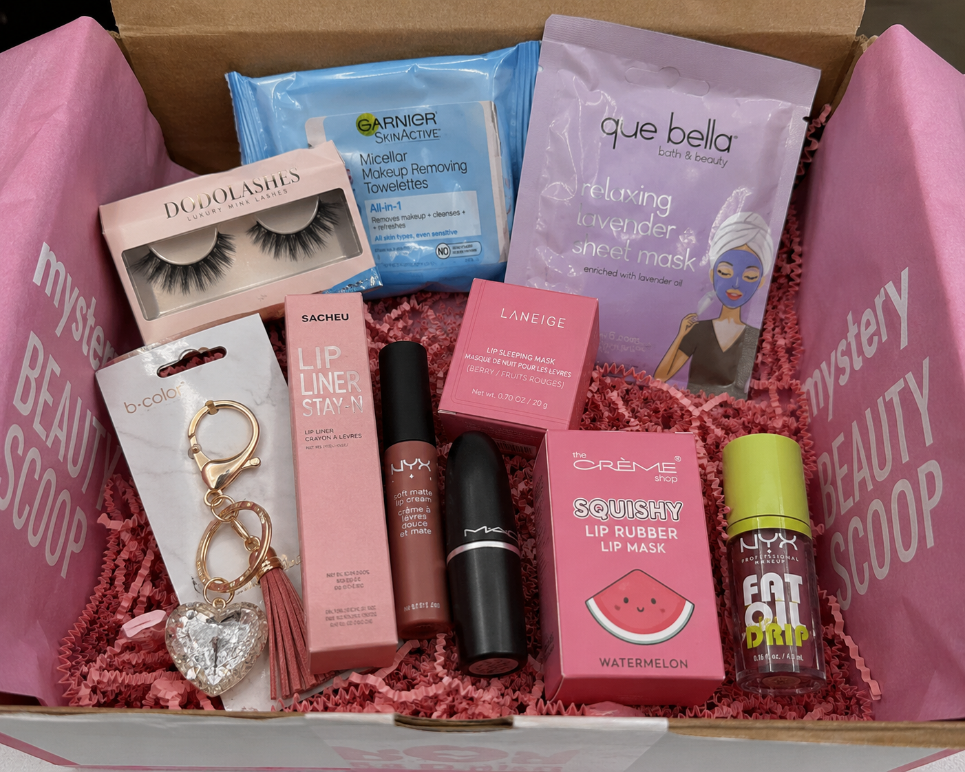 Assorted beauty products in a box labeled 'Mystery Beauty Scoop' 